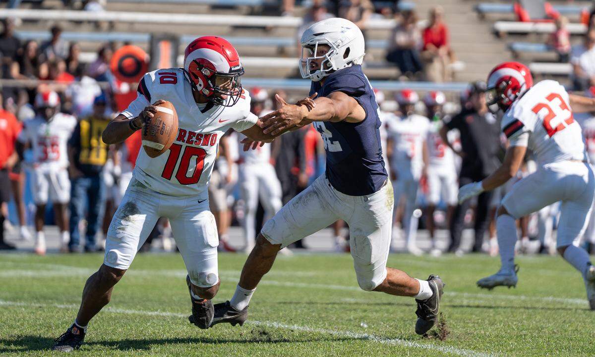 Modesto JC defensive lineman Jalonn Booth tries to sack Fresno City College quarterback Ya’j Vance during a Valley Conference game at Modesto Junior College on Saturday, Oct. 11, 2025.