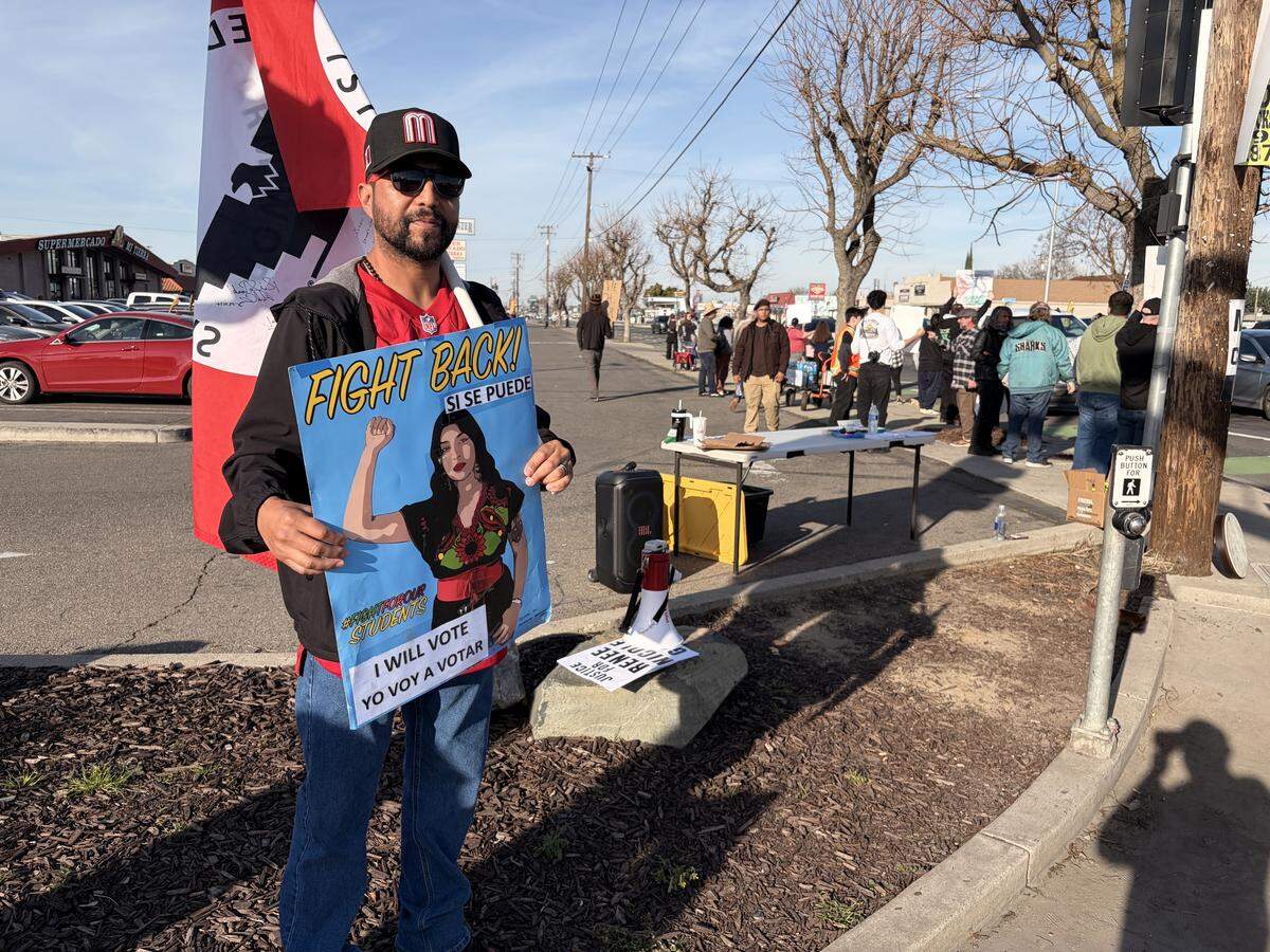Armando Mendoza, 46, of Modesto, holds up a sign and a United Farm Workers flag at the anti-ICE rally at the intersection of Hatch and Crows Landing roads in south Modesto on Saturday, Jan. 10, 2026.