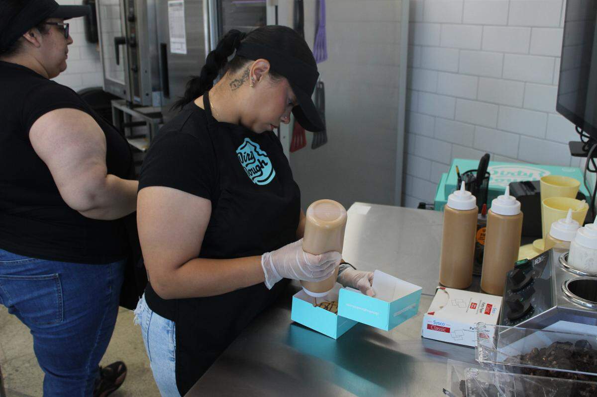 Hazel Armenta, a crew member, assembles a cookie order.