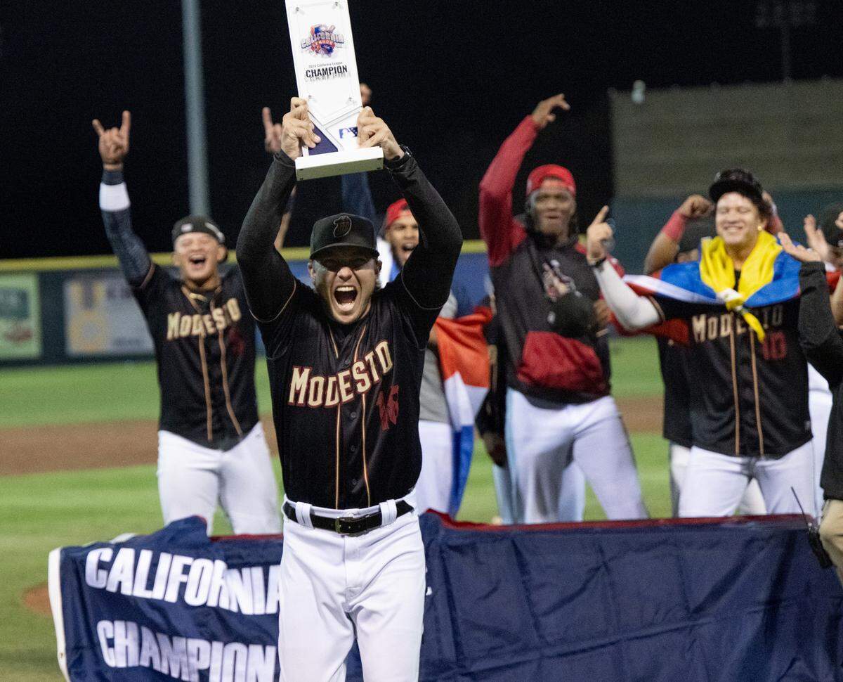 Modesto Nuts’ manager Zach Vincej holds up the California League Championship trophy toward the crowd at John Thurman Field in Modesto, Calif., Wednesday, Sept. 18, 2024.