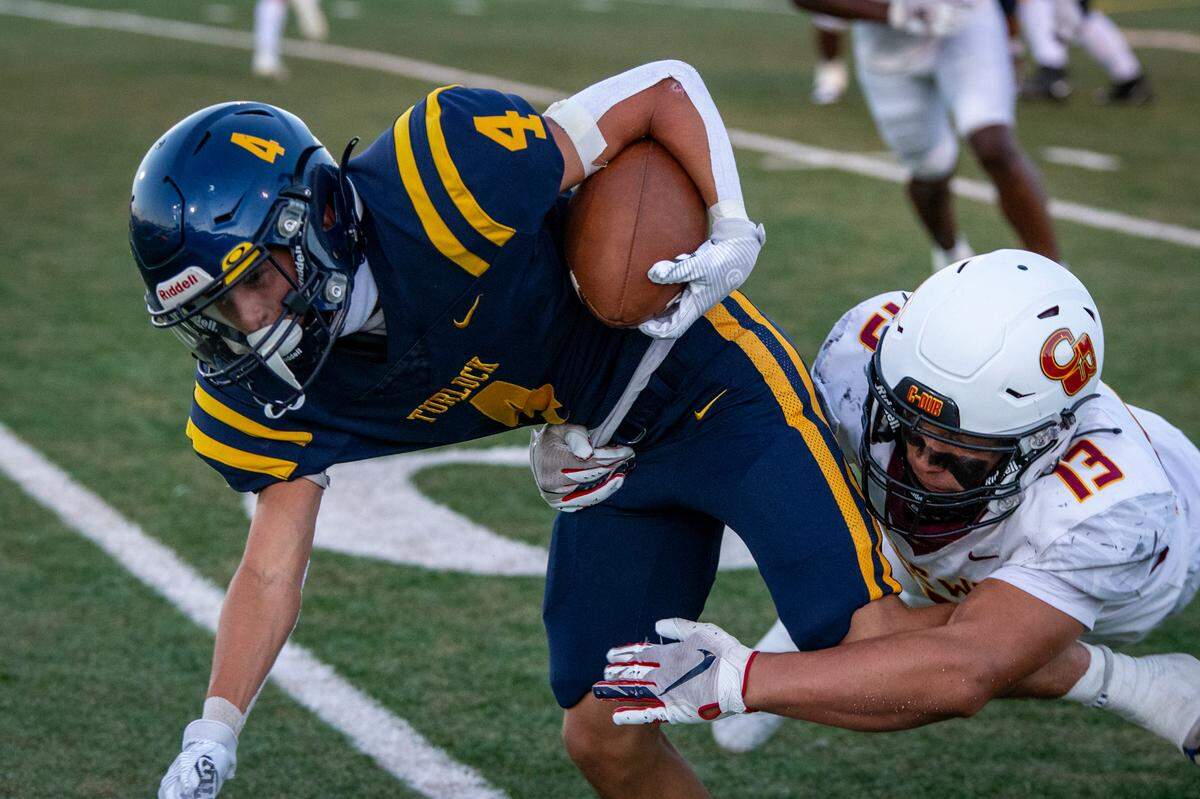 Turlock High’s Junior Silva (4) is taken down by Clovis West defender Michael Espinoza (13) of Clovis West during the first half of Friday’s game in Turlock.