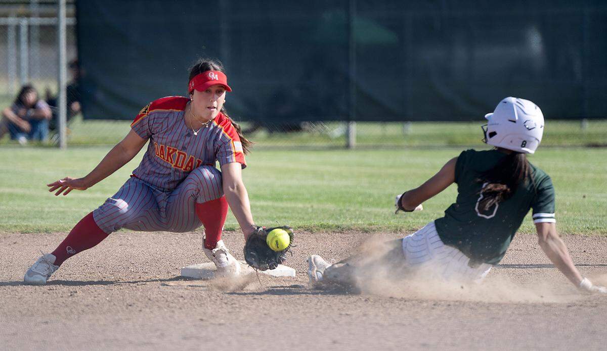 Manteca’s Ayva Wilkins beats the tag from Oakdale’s Madi Bohannon during the Valley Oak League game at Oakdale High School in Oakdale, Tuesday, April 29, 2025.