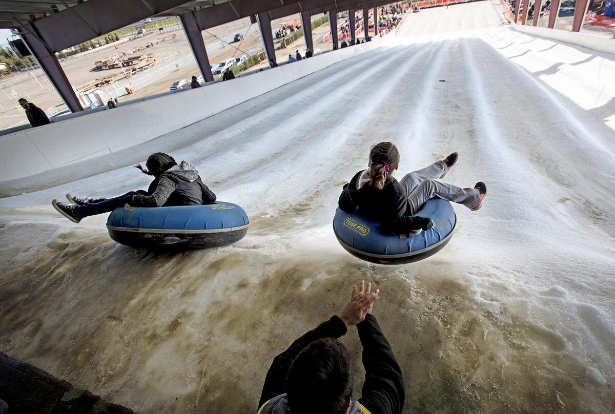 Kids tube down snow mountain during Holidays on the Farm at Dell’Osso Family Farm in Lathrop, Calif., on Saturday, Dec. 17, 2016.