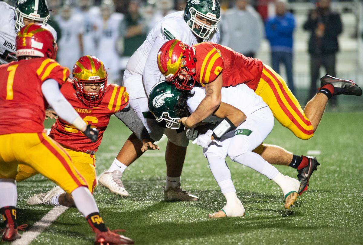 Oakdale’s Brock Osmondson stops Manteca’s Lyon Colon behind the line during the Sac-Joaquin Section Division III championship game at St. Mary’s High School in Stockton, Calif., on Friday, Nov. 25, 2021.