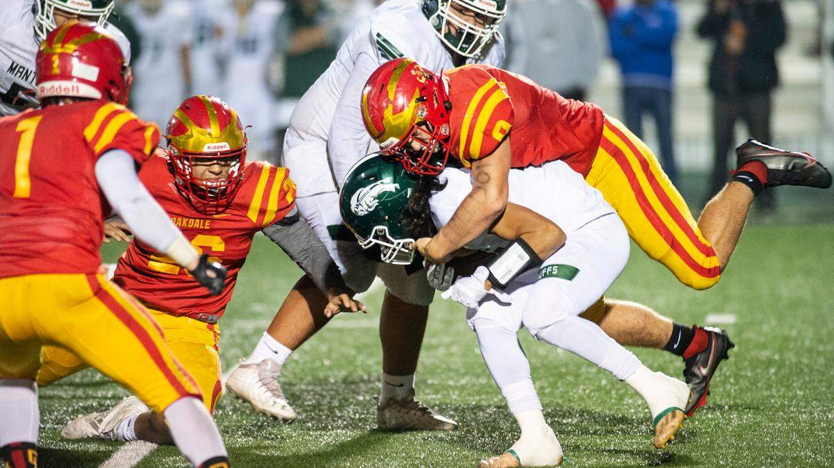 Oakdale’s Brock Osmondson stops Manteca’s Lyon Colon behind the line during the Sac-Joaquin Section Division III championship game at St. Mary’s High School in Stockton, Calif., on Friday, Nov. 25, 2021.