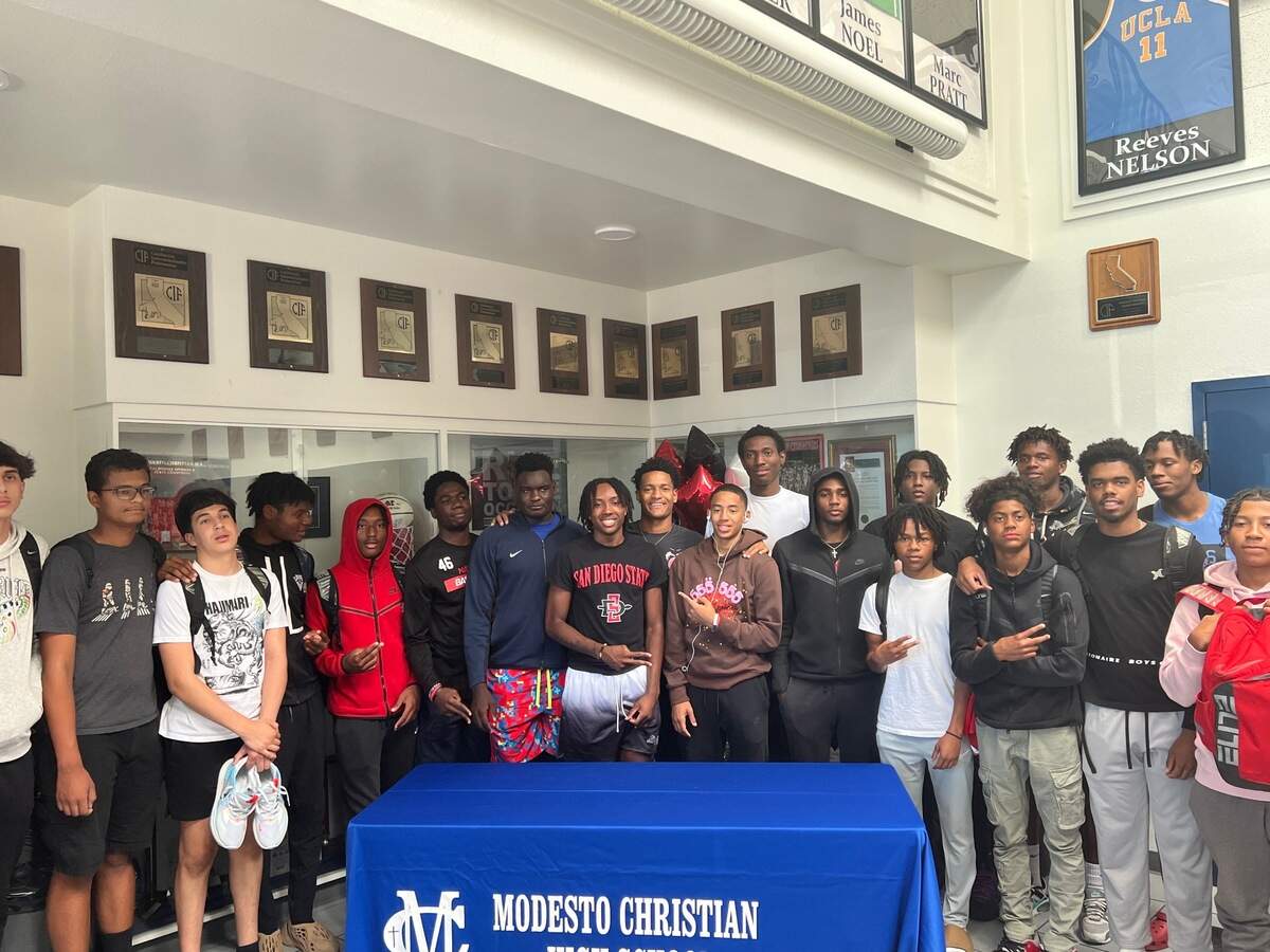 Modesto Christian guard BJ Davis takes a picture with teammates at his commitment ceremony in the Modesto Christian gym on Friday, September 23, 2022.
