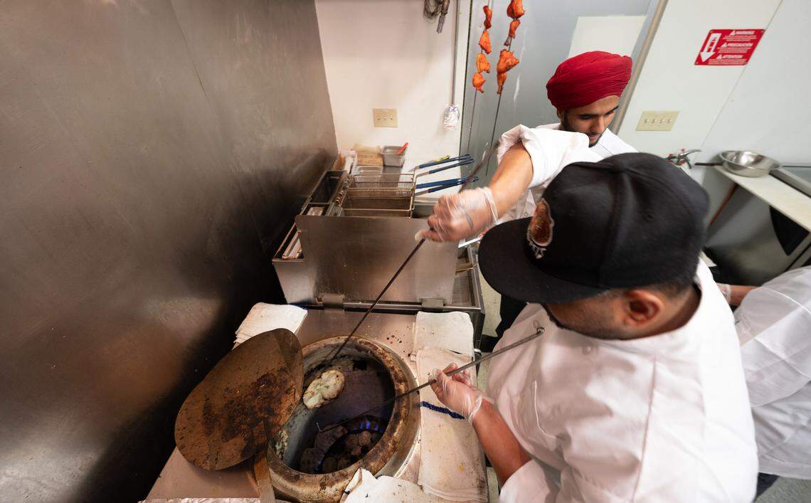 Cooks prepare naan at Tandoori Flame restaurant on 10th Street in Modesto, Calif., Wednesday, Sept. 27, 2023.