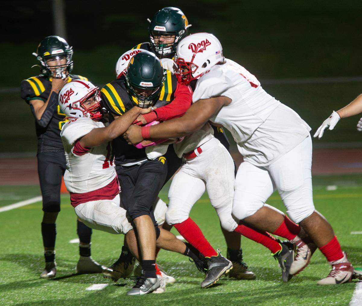 Ezekiel Suarez, 1, of Davis High gets taken down by the Ceres High defensive line during a WAC game against Ceres High on Friday Oct. 27, 2023.