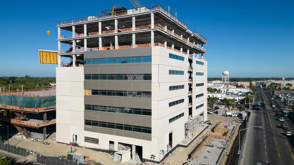 A crane lowers siding material as construction continues to work on the new Stanislaus County Superior Courthouse in Modesto, Calif., Friday, July 28, 2023.