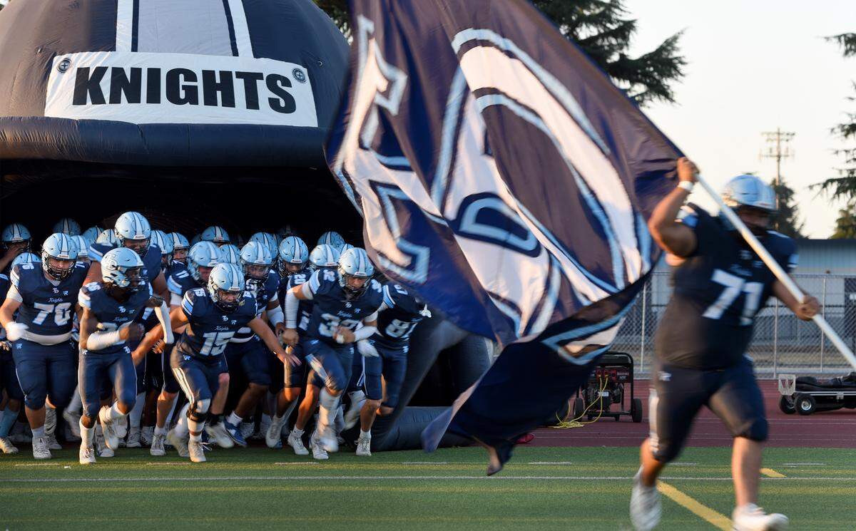 Downey players take the field during the nonleague game with Merced at Downey High School in Modesto on  Friday, Sept. 5, 2025.