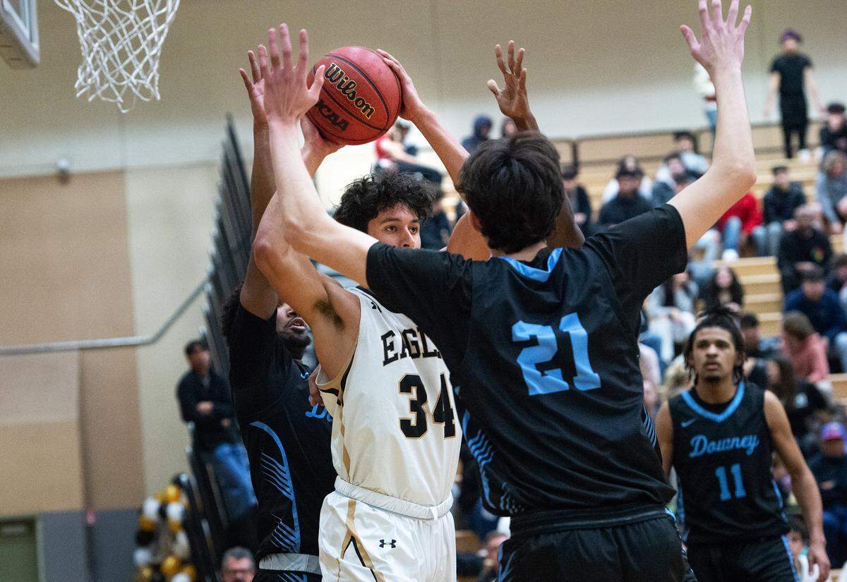 Enochs’ Emiliano Arreola looks to pass as Downey’s Collin Eden defends during the Central California Athletic League game at Enochs High School in Modesto, Calif., Friday, Jan. 27, 2023. Downey won the game 47-40.