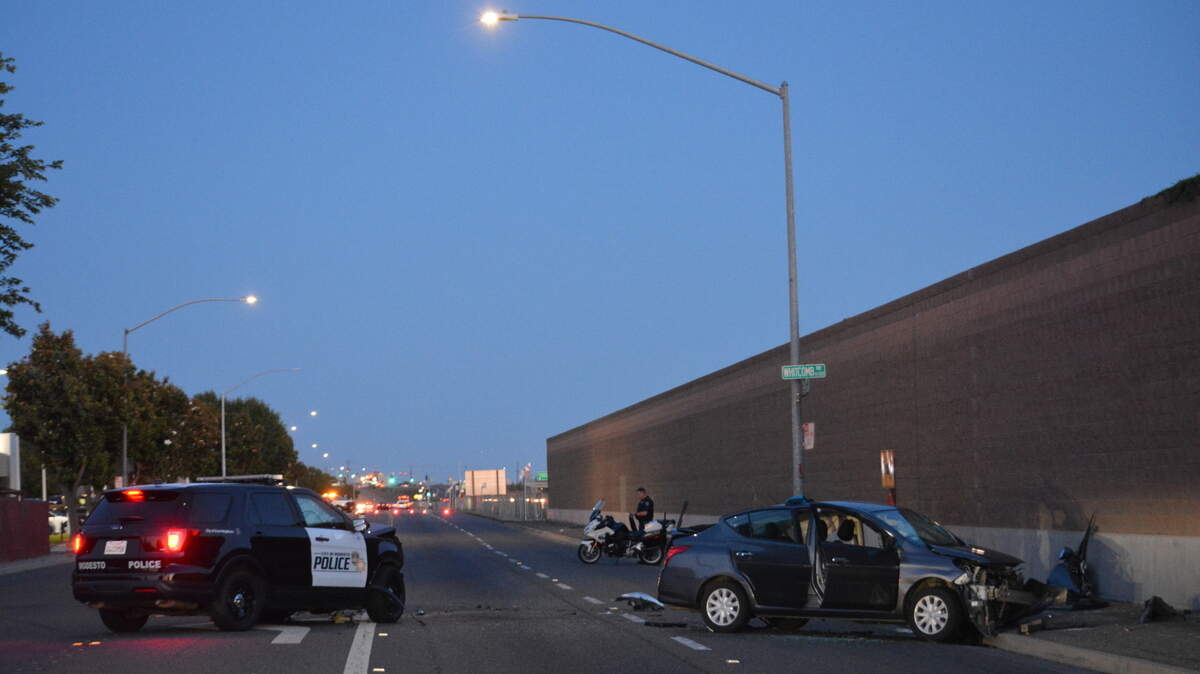 A Modesto police officer surveys the scene where a police SUV was hit by an apparent drunk driver on Monday, June 6, 2022. No one was critically injured, police said.