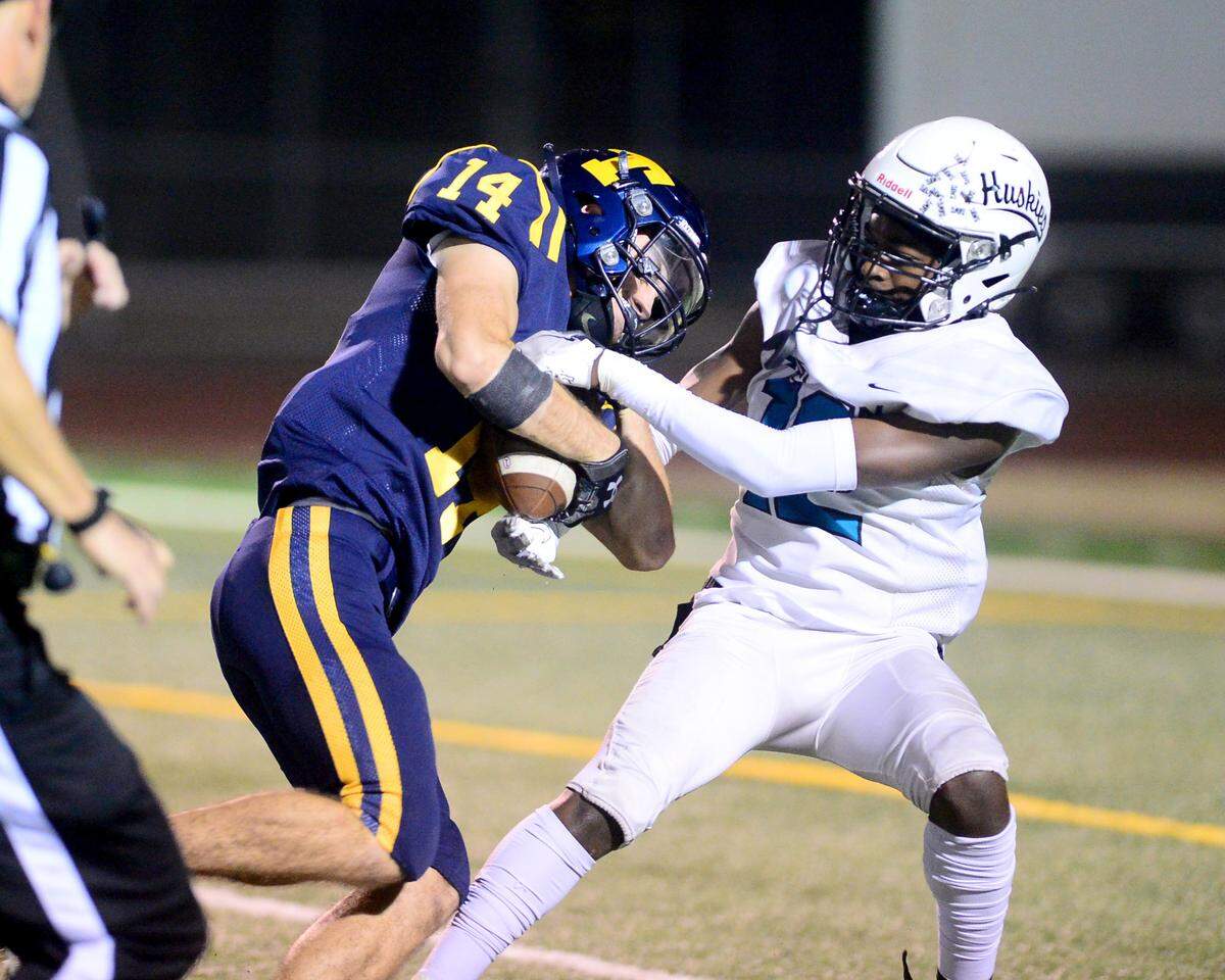 Turlock receiver Carter Crivelli (14) and Sheldon’s Ja King Williams (12) fight for the ball after Crivelli made the catch during a CIF Sac-Joaquin Section Football Division I playoff game between Turlock High School and Sheldon High School at Turlock High School in Turlock, California on Nov. 3, 2023.