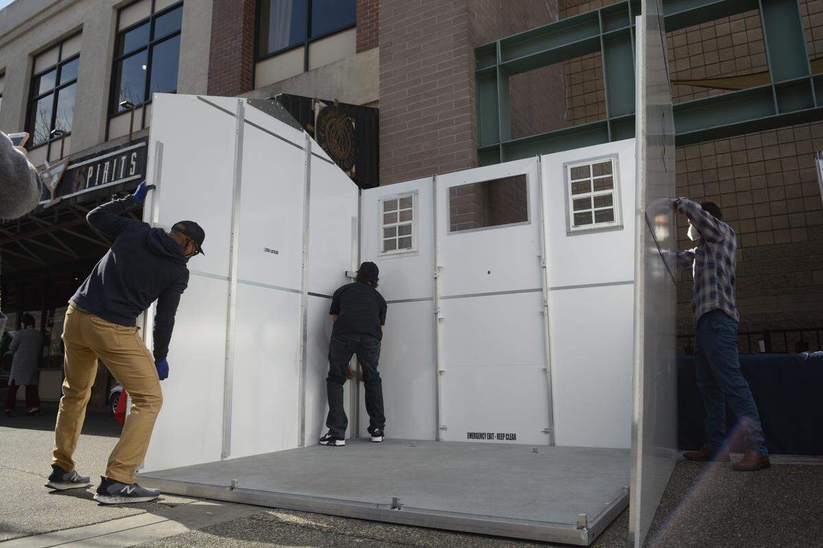 A crew from Pallet Shelter builds a 100-square-foot home with two beds on Tuesday, March 2, 2021 in Modesto, California.