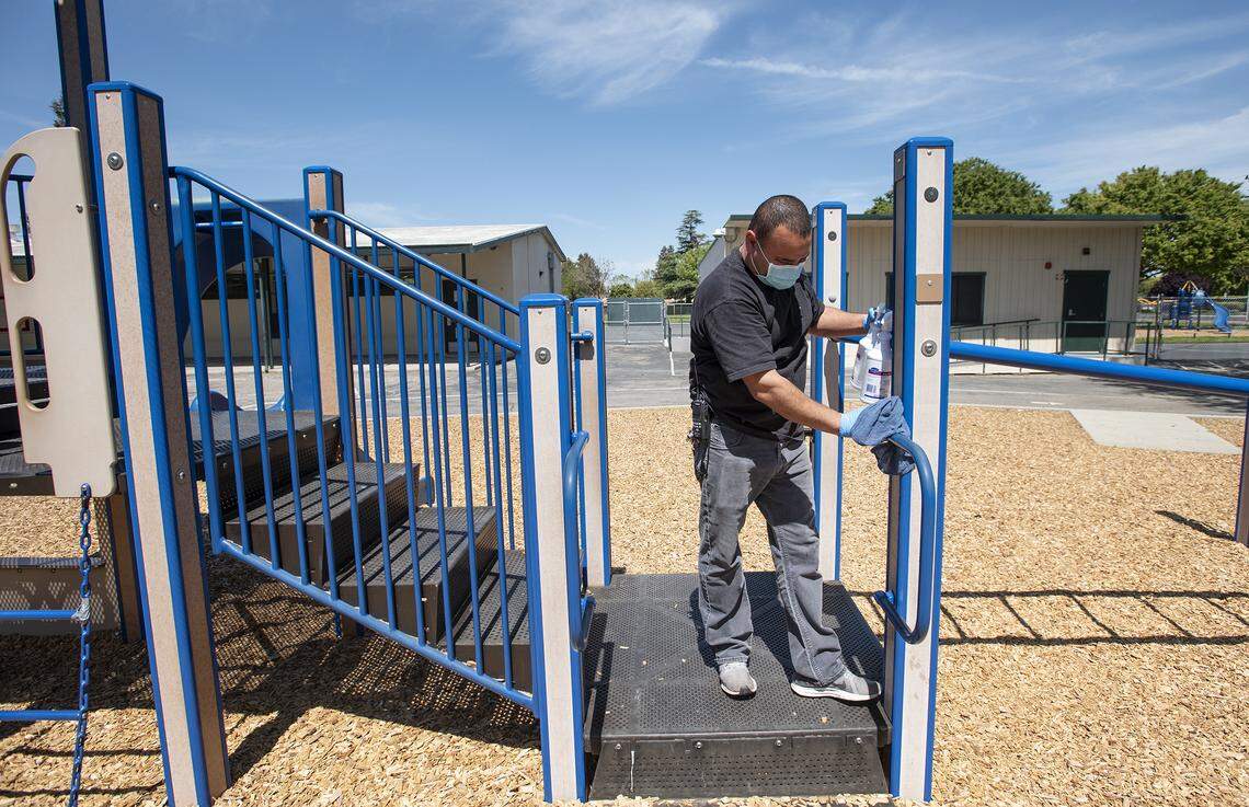 Head custodian Jose Hurtado disinfects the playground structure at Muir Elementary School in Modesto, Calif., on Tuesday, April 14, 2020. Modesto City Schools has been aiding health care workers, public safety first responders and its own nutrition services employees with free child care at one of its centrally located elementary campuses.