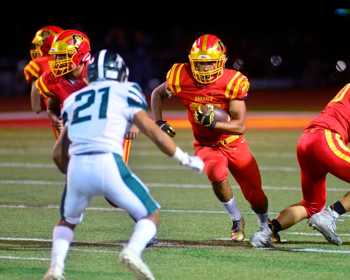 Oakdale running back Zeke Saffar runs through the hole during a game between Oakdale High School and Manteca High School at Oakdale High School in Oakdale, CA on October 4, 2019.