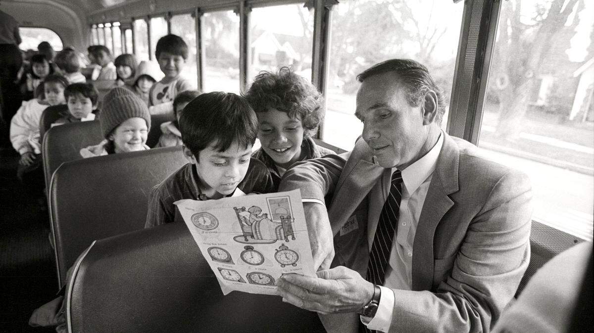 Modesto City Schools Superintendent James Enochs takes a bus ride with children from the Modesto School District to see for himself how employee Linda Butler handles the children during a normal day on the road. Children are (L to R) Ismael Lopez, 7, and Justice Mitchell, 7, both in the first grade from Franklin Elemamentary School Wednesday, Feburary 11, 1987.