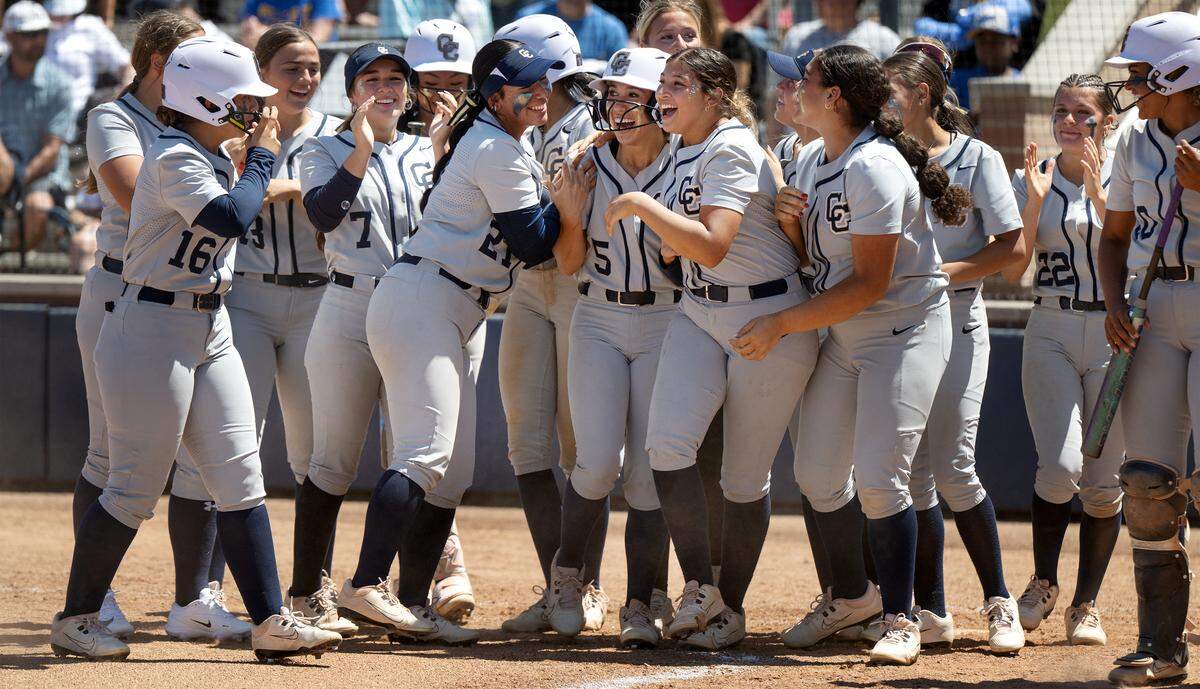 Central Catholic players celebrate with Carsyn Lomeli-Garcia (5) at home plate after a grand slam home run in the Sac-Joaquin Section D-IV softball championship game with Wood of Vacaville at Cosumnes River College in Sacramento, Saturday, May 23, 2026. The Raiders won the game 8-3.