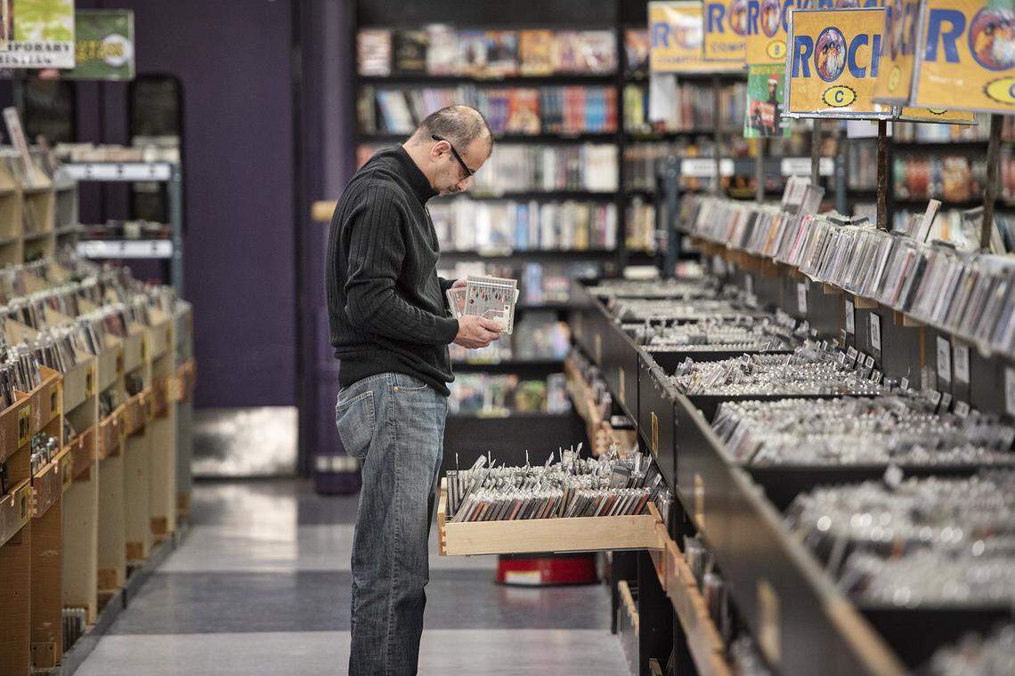John Ishaya shops for music cd’s at Mad Monk, combination music-movies store and used clothing shop, in Modesto, Calif., on Wednesday, Dec. 18, 2019.