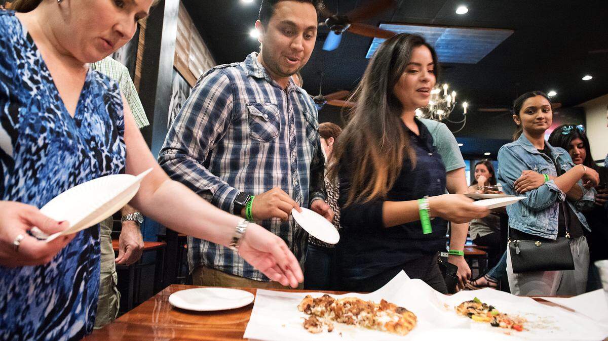 Dana Kirk of Waterford, left, Prab Gill, middle, and Vanessa Vidal, right, both of Tracy, sample pizza at St. Stans Brewery during the Downtown Sampler event in Modesto, Calif., on Tuesday, Oct. 2, 2018.