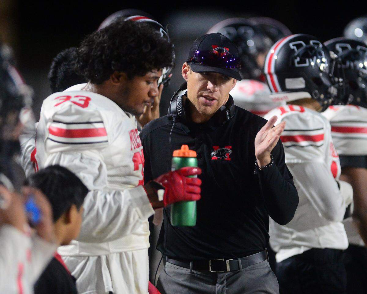 Modesto High coach Dylan Miller talks to Jalyn Woods during a game against Enochs at Johansen High School in Modesto, Calif., on Oct. 28, 2022.