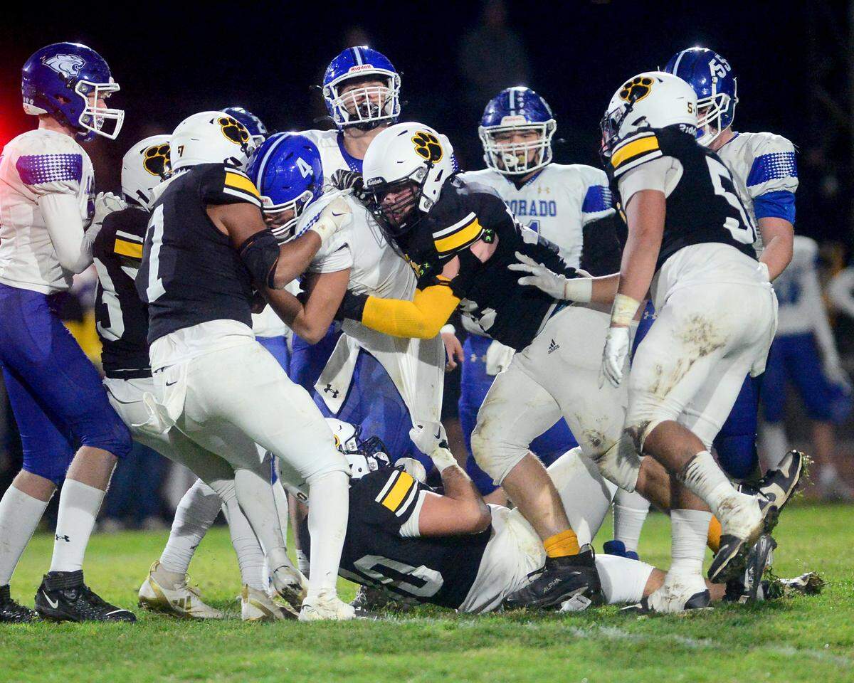 Hughson defenders Valente Soria (7) and Colton Taylor (72) sack the El Dorado quarterback Jason Wilson during a 2024 CIF Sac-Joaquin Section Division V Playoff game between Hughson High School and El Dorado High School at Hughson High School in Hughson California on November 15, 2024. Hughson won the game 28-6.