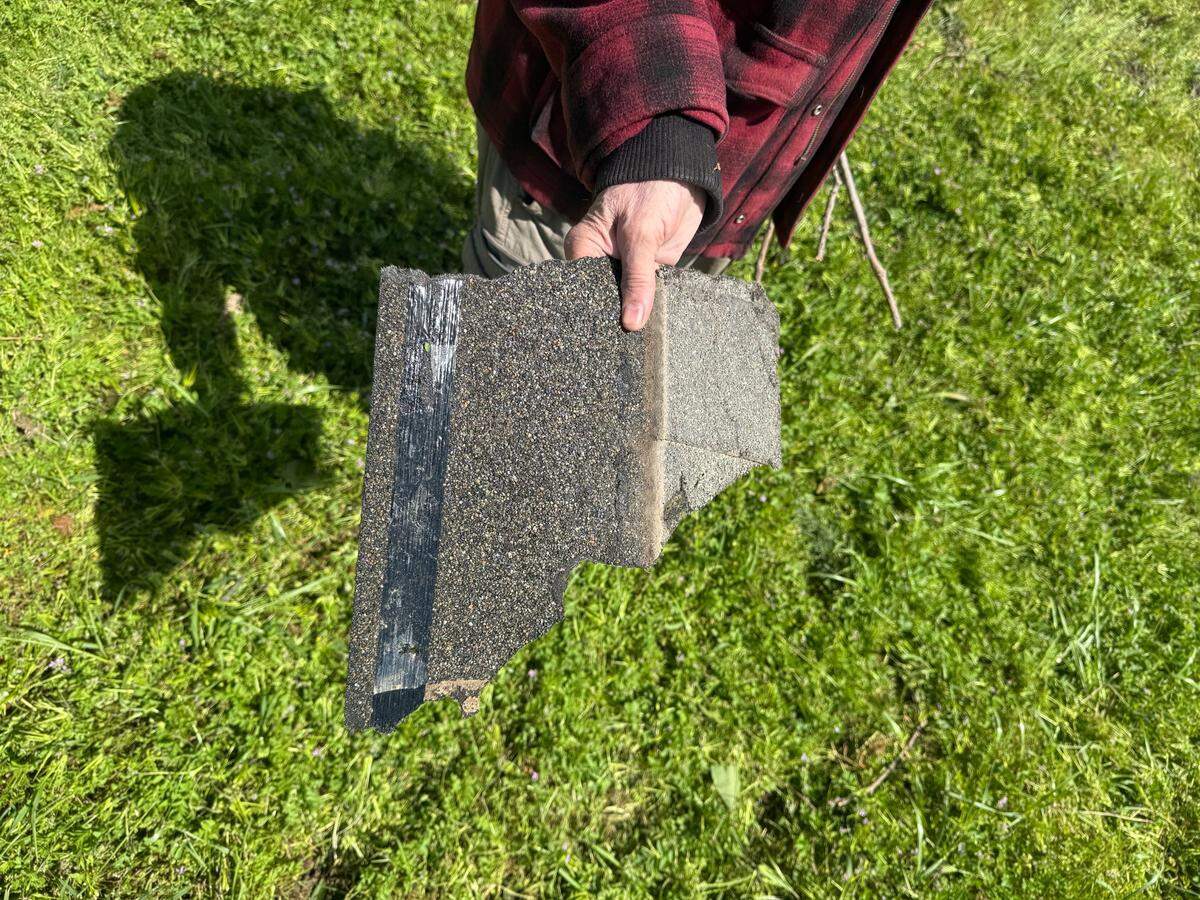 Gary Wheeler with a piece of a roof from a property three houses down Kiernan Avenue after a tornado touched down in Modesto on Tuesday, April 1.