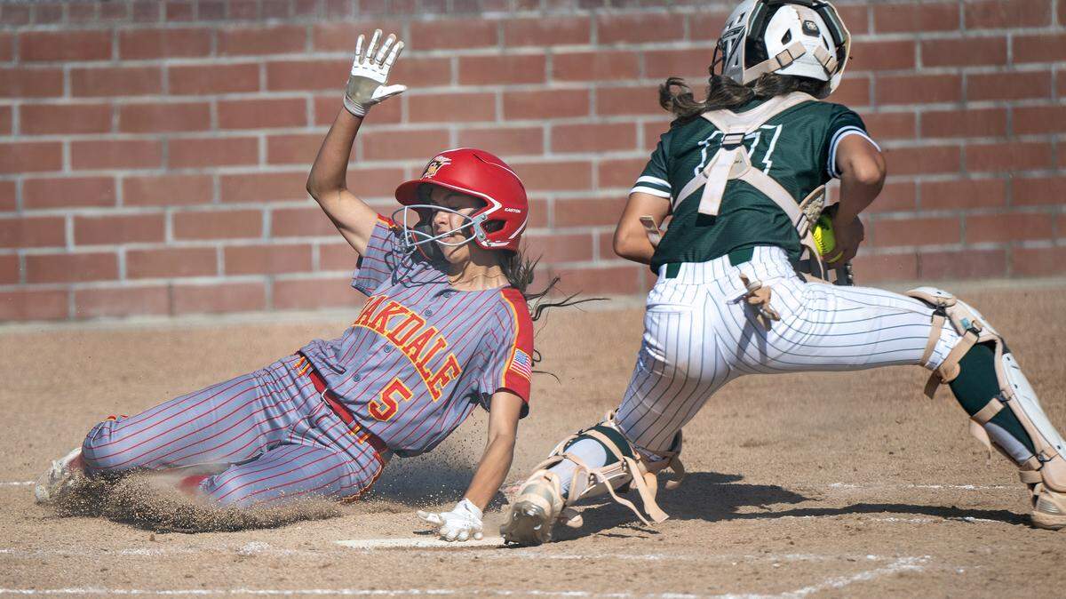 Oakdale’s Grace Constant scores past Manteca’s Lauren Moncada during the Valley Oak League game at Oakdale High School in Oakdale on Tuesday, April 29, 2025. Oakdale won the game 10-8.