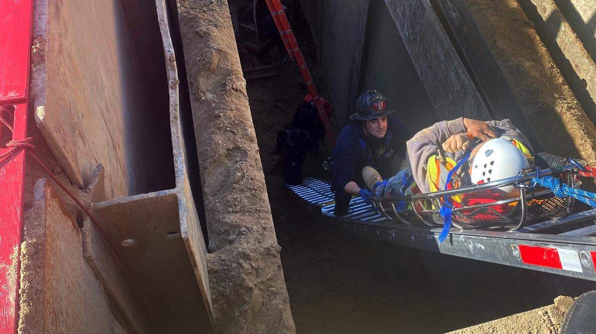 Modesto firefighters rescue a man who fell nearly 30 feet behind a metal plate holding a trench together where a construction crew is installing sewer pipes.
