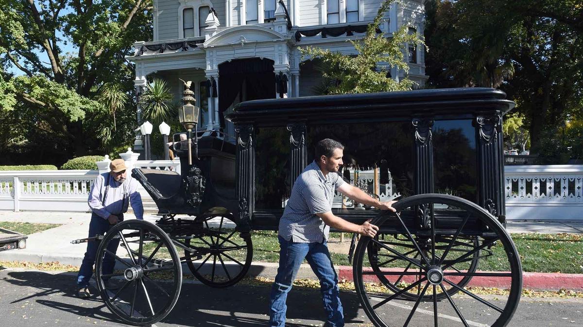 Father and son Antonio (center) and Tony T. Azevedo of The Double T put a hearse built in the 1860’s in place Monday morning October 28, 2019 in front of the McHenry Mansion in downtown Modesto, Calif. The mansion will hold self-guided tours of Victorian funeral customs starting tonight through the 30th.