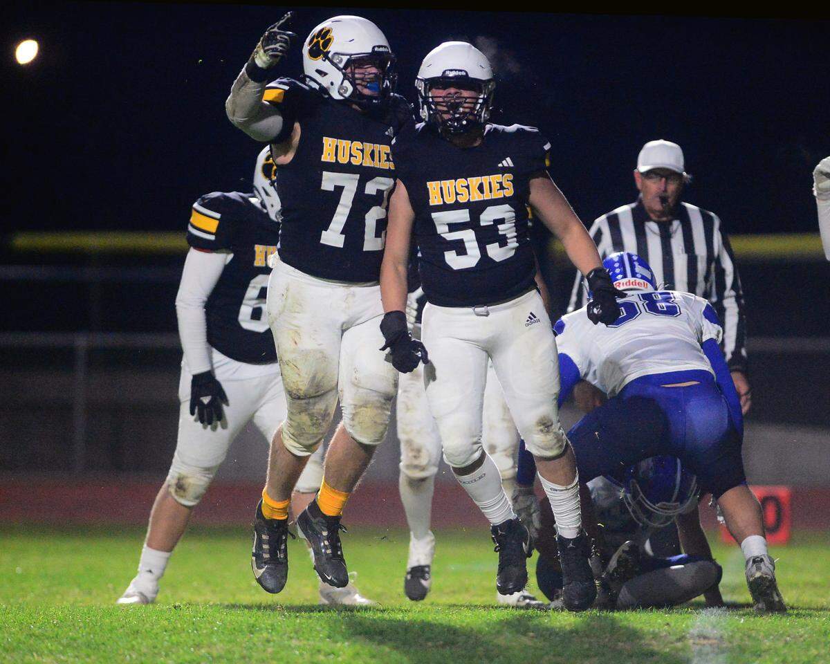 Hughson defenders Colton Taylor (72) and Brady Caldwell (53) celebrate a sack during a 2024 CIF Sac-Joaquin Section Division V Playoff game between Hughson High School and El Dorado High School at Hughson High School in Hughson California on November 15, 2024. Hughson won the game 28-6.