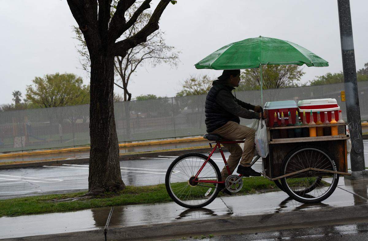 A street vendor rides during a rainstorm in Modesto, Calif., Tuesday, March 28, 2023.