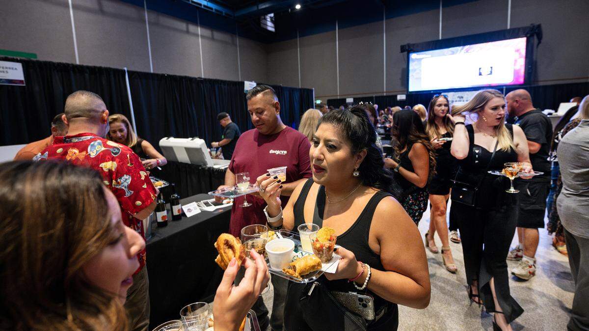 Carmen Albart, middle, and other guests sample food and drinks during Edible Extravaganza fundraising event for the Center for Human Services in Modesto, Calif., Thursday, Oct. 5, 2023.