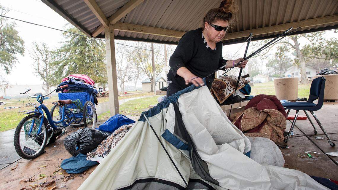 Crystal, a homeless resident, gathers up possessions before city workers arrive to remove what city officials say is illegally stored property at Broadway Park in Turlock, Calif., Wednesday, Jan. 9, 2019.