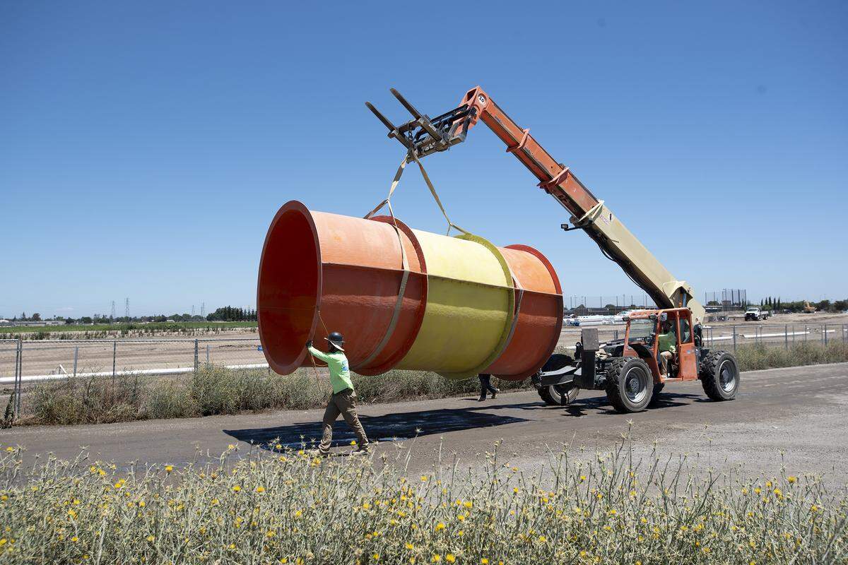 Workers move a section of the water slide during construction at the Great Wolf Lodge Resort in Manteca, Calif., Thursday, July 11, 2019.