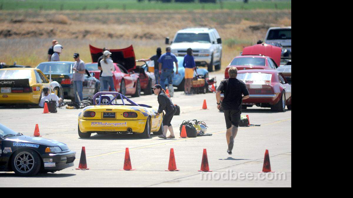Drivers, crew members, and race volunteers hurry to make adjustments to their race cars before taking them back to one of two courses set up by the San Francisco Region of the Sports Car Club of America Saturday morning (08-10-13) at the former Crows Landing Naval Air Base south of Patterson.
