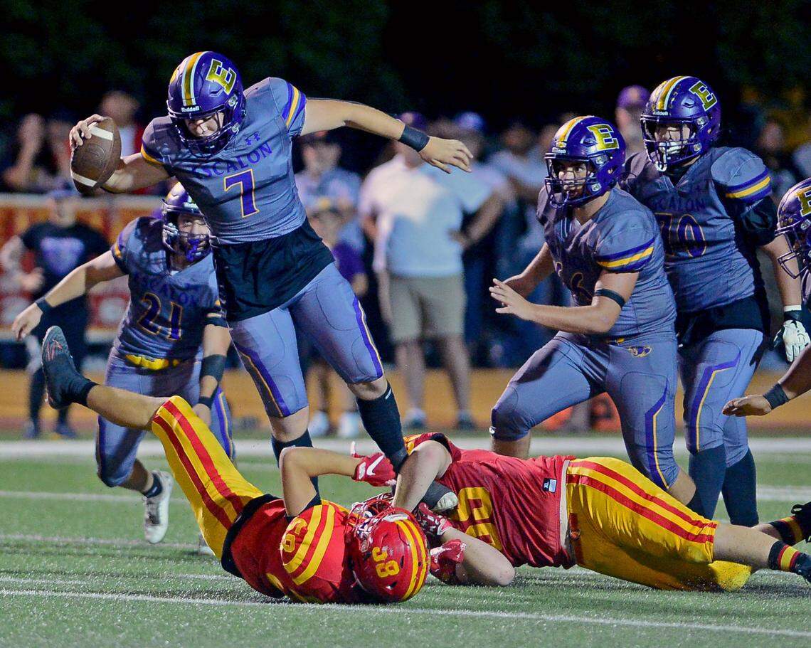 Escalon quarterback Donovan Rozevink (7) jumps over a defender to escape pressure during a game between Oakdale and Escalon at Oakdale High School in Oakdale, California, on September 15, 2023.