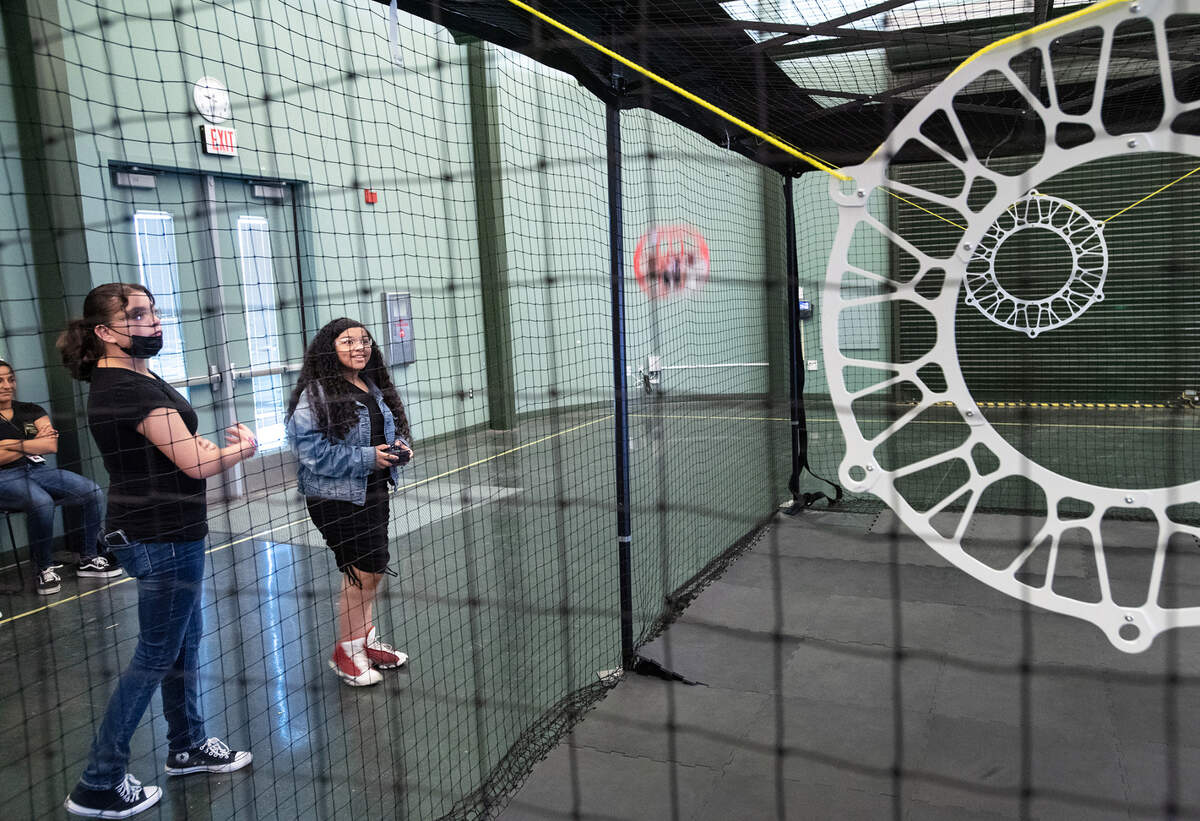 Nikole Amador, 12, middle, pilots a drone in the soccer field as classmate Xitlali DeLaCruz, 11, left, watches during Drone Soccer camp at Modesto Junior College in Modesto, Calif., on Friday, June, 24, 2022.