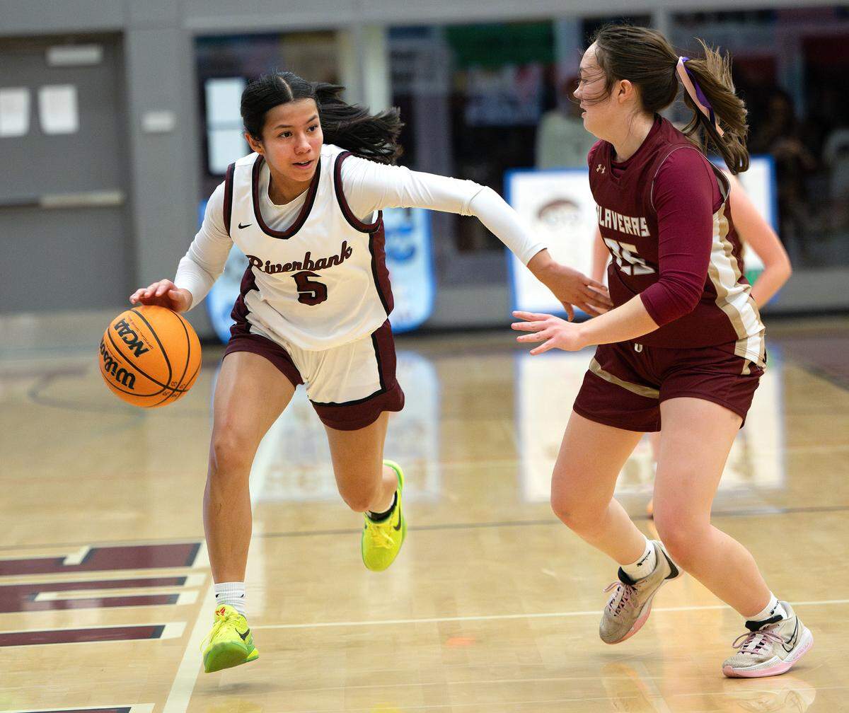 Riverbank’s Leilani Olanolan moves the ball up court as Mariah Maddock of Calaveras defends during the Mother Lode League game in Riverbank, Friday, Jan. 31, 2025.