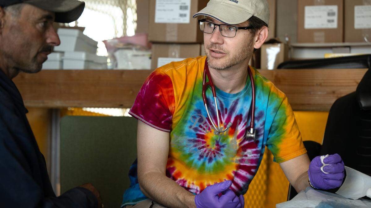 Valley Streetz Harm Reduction physician Dr. James Kraus, right, helps James Black with an open wound at The Rock Church in Modesto, Calif., Friday, April 12, 2024. The program provides harm reduction services and medical treatment at the church on Friday mornings.