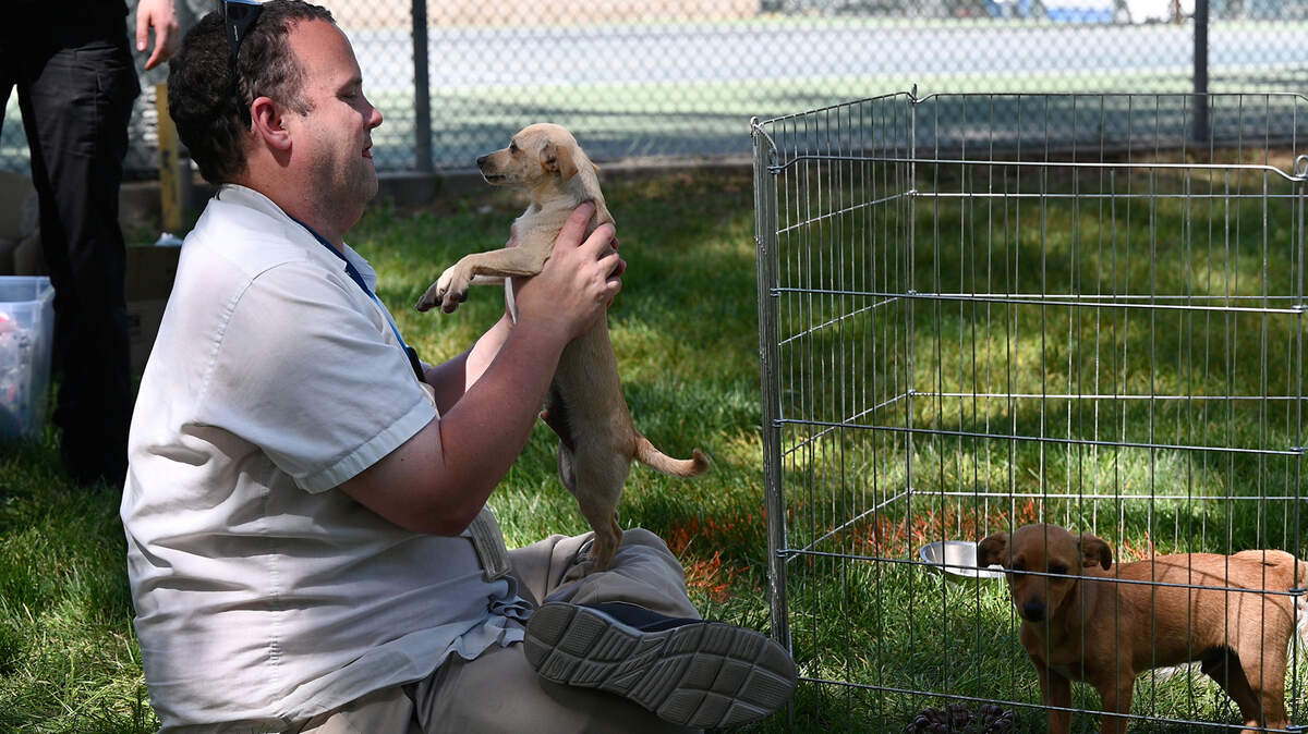 Stanislaus Animal Services Agency volunteer Craig Boyer plays with a shelter dog during the Earth Day celebration at Graceada Park in Modesto, Calif., Saturday, April 22, 2023.