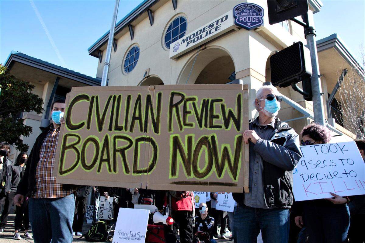 Thomas Helme (left) and Tom Crain attend a protest in front of the Modesto Police Department against the fatal shooting of Trevor Seever in Modesto, Calif., on Jan. 9, 2021.