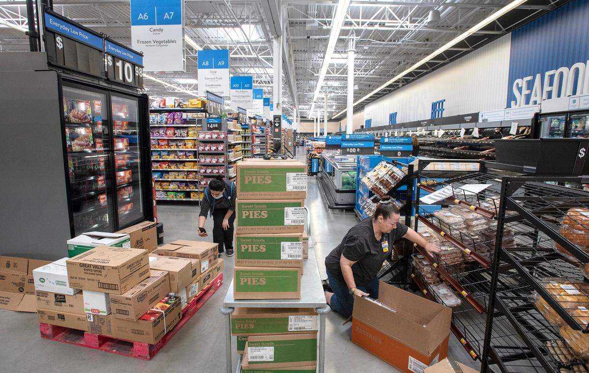 Paula Berg, right, helps stock the bakery department at the Walmart Supercenter in Ceres ,Calif., on Wednesday, Nov. 17, 2021.