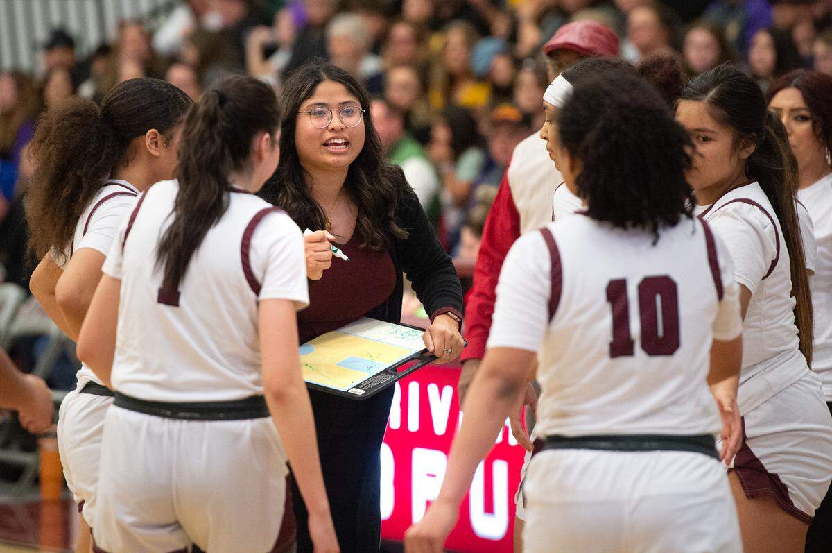 Riverbank coach Janelle Luu talks with her players during a time out in the Sac-Joaquin section semifinal playoff game in Riverbank, Calif., Tuesday, Feb. 21, 2023. The Riverbank girls basketball team advanced to play Colfax in the Division IV section final after beating TVL rival Escalon 58-41 in the semifinals.