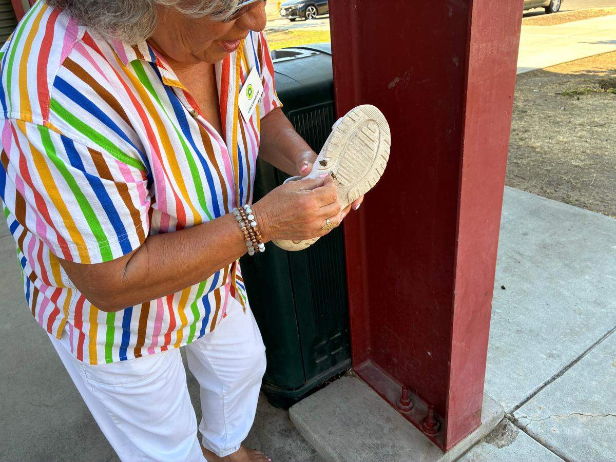 Lilia Lomeli-Gil picks a piece of wood out of her shoe at Grayson United Community Park July 24, 2025.