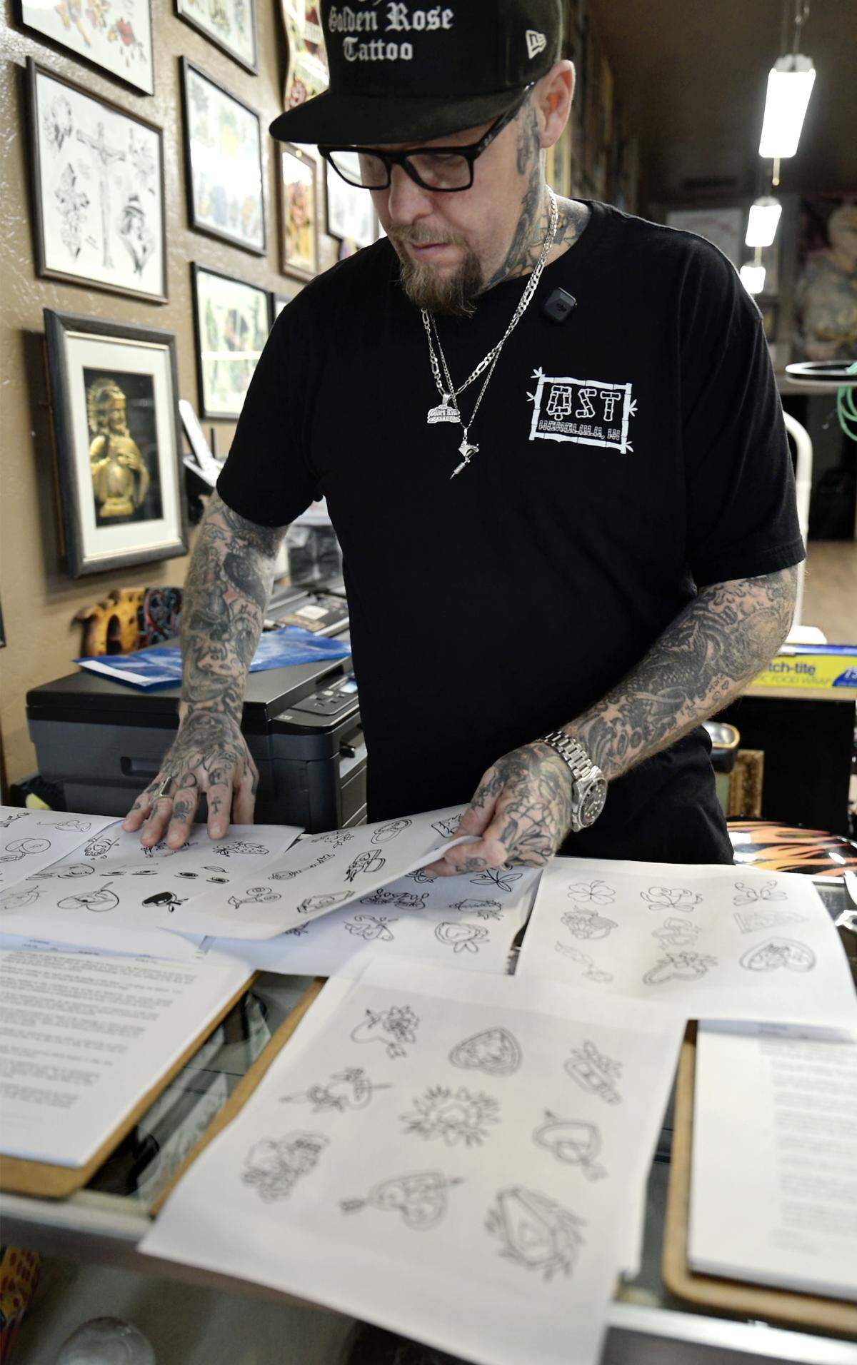 Artist Corey Young, owner of The Golden Rose Tattoo, prints out some stencils for the Friday the 13th flash tattoos. 