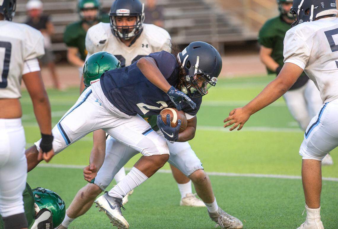 Downey runner takes on Sonora defenders during a pre-season scrimmage at Downey High School in Modesto, Calif., on Friday, Aug. 13, 2021.