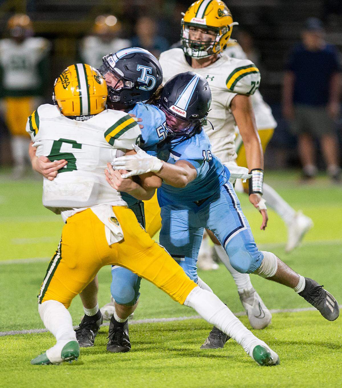 Downey’s Ricky Horton and Matthew Flores wrap up Tracy’s Elijah Gutierrez for a loss during the nonleague game with Tracy at Downey High School in Modesto, Calif., on Friday, September 16, 2022.