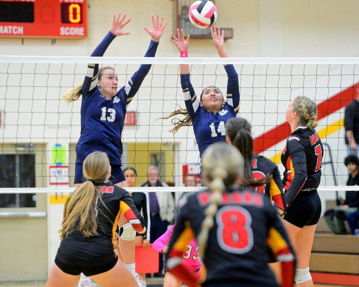 Central Catholic’s Czyleah Pabustan (14) and Marie Wildenberg (13) jump to block the ball during a game between Oakdale and Central Catholic at Oakdale High School in Oakdale, Calif. on Thursday, Oct. 17, 2024.&nbsp;