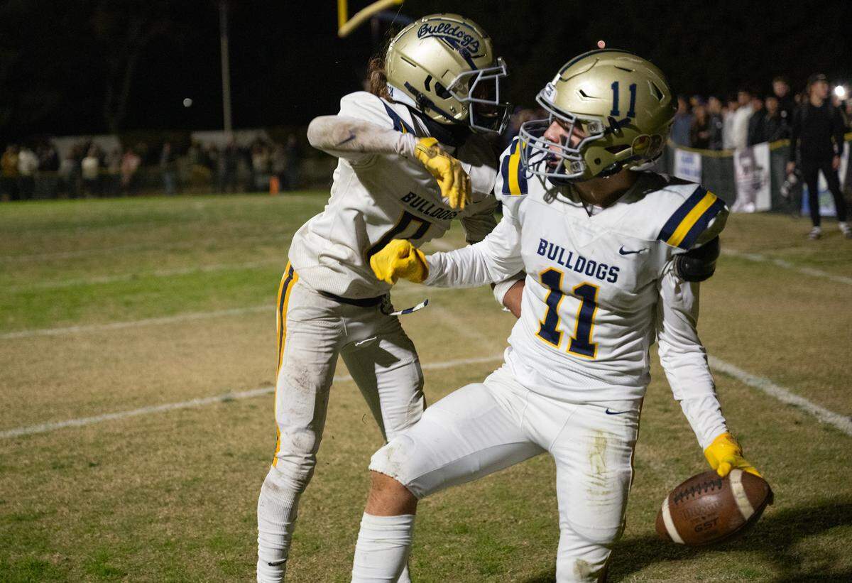 Turlock players Jeremiah Stine and Landyn Fitzgerald (11) celebrate a touchdown in the endzone during the Sac-Joaquin Section Division I playoff game with Central Catholic at Central Catholic High School in Modesto, Friday, Nov. 15, 2024.